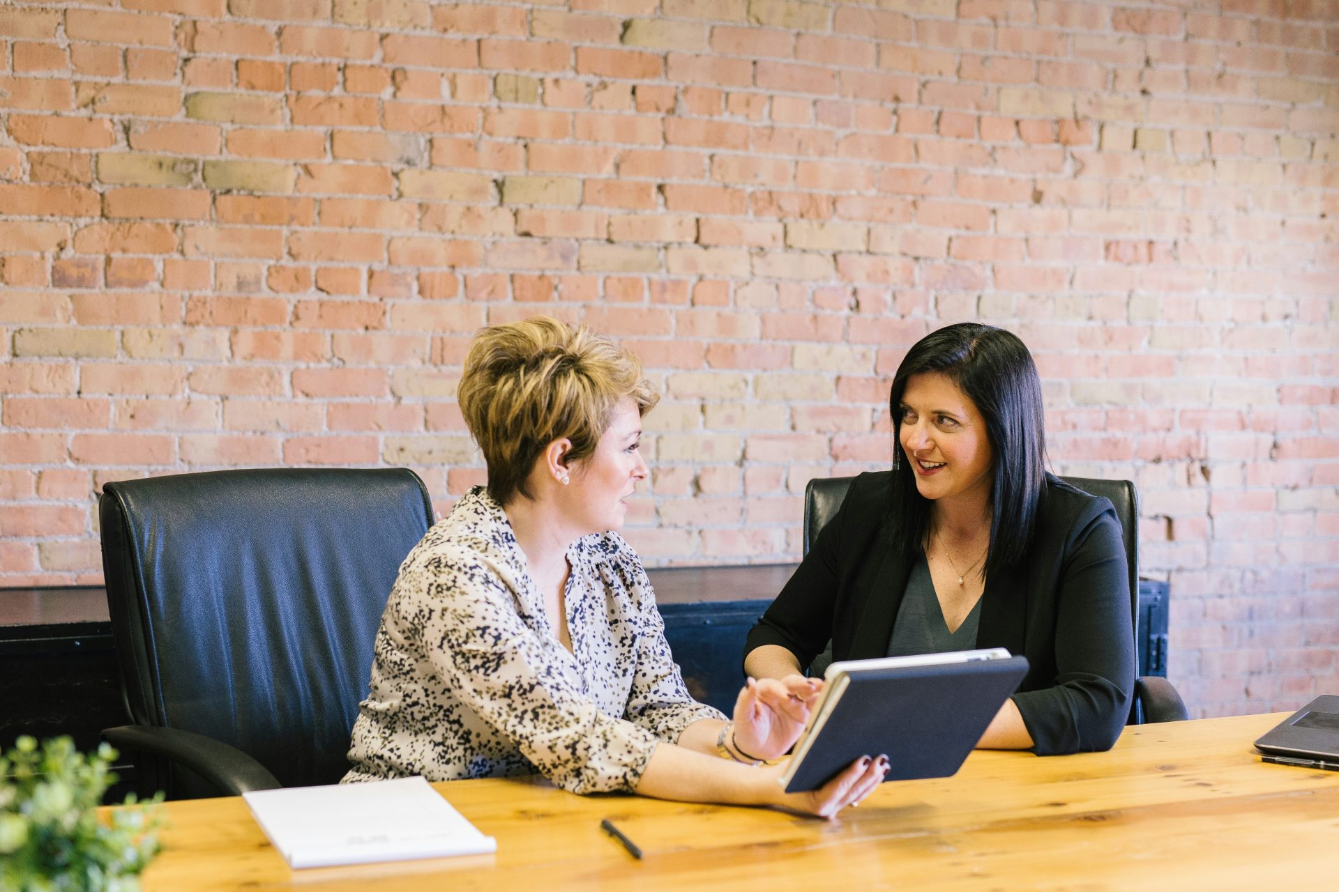 Two women having a serious discussion, laptops