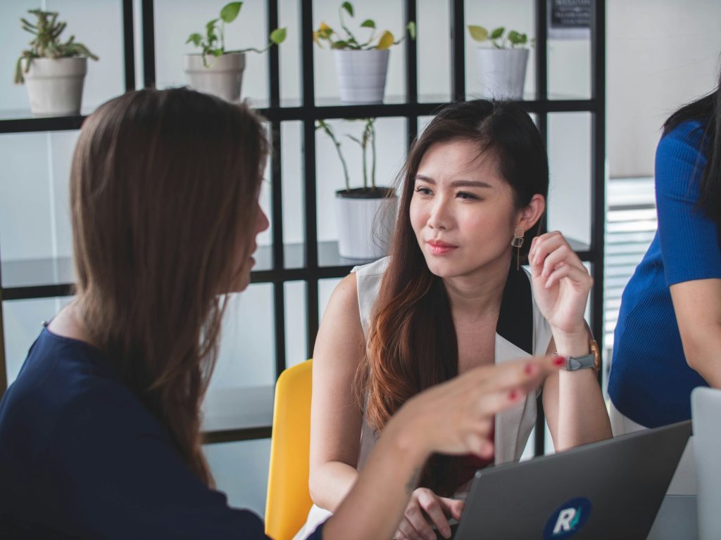 Two women having a serious discussion, laptops