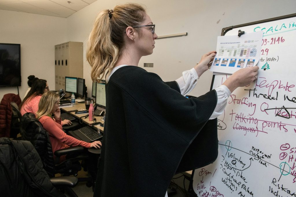 Woman presenting information on whiteboard in office